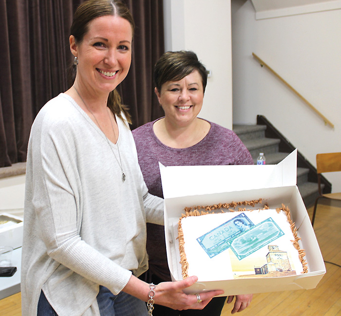 Kari Kosior and Charlotte Stephen with the Fleming Elevator and Canada $1 bill cake that went for $470.<br />